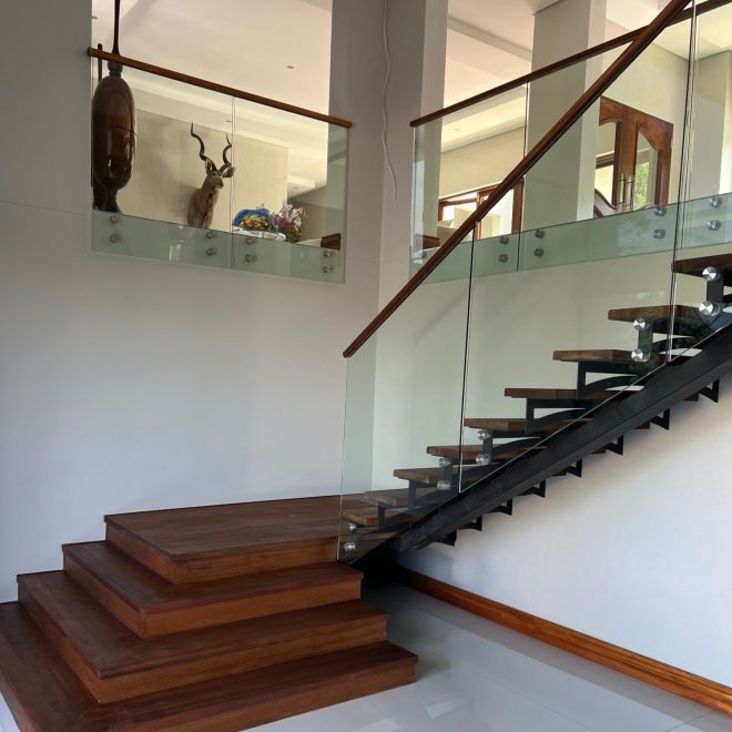 Single stringer Staircase Meranti wood threads, clear glass balustrade finished with elegant Meranti wood infills - Residential