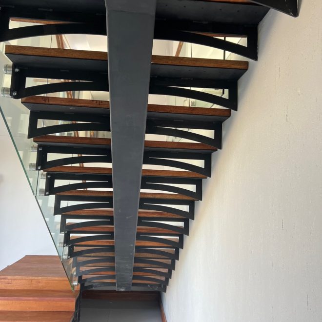 Single stringer Staircase Meranti wood threads, clear glass balustrade finished with elegant Meranti wood infills - Residential