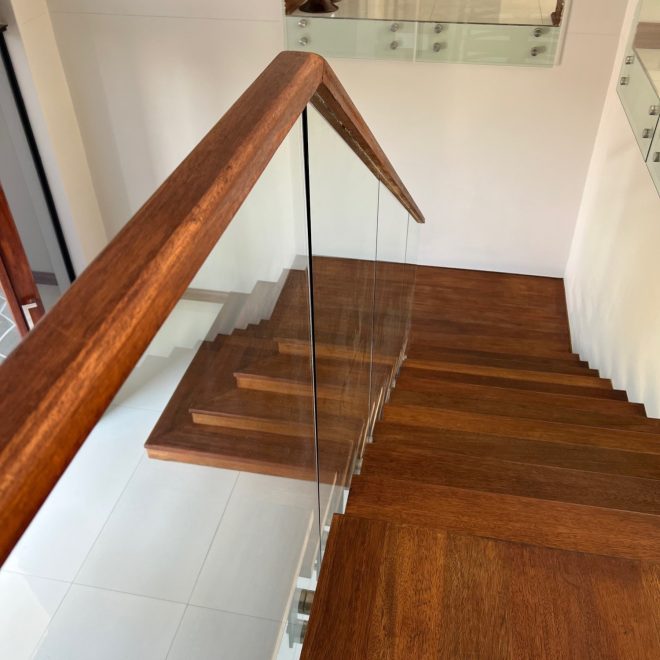 Single stringer Staircase Meranti wood threads, clear glass balustrade finished with elegant Meranti wood infills - Residential